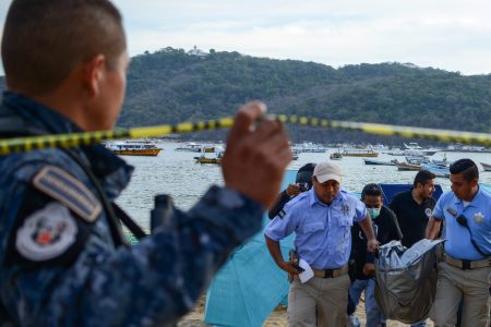 Forensic personnel and police officers carry the body of a murdered man, at Caletilla beach, in the touristic city of Acapulco, Guerrero State, Mexico, on March 18, 2018.
Guerrero is one of Mexico's poorest and most violent states, where a lucrative drug trade has flourished. (FRANCISCO ROBLES/AFP/Getty Images)