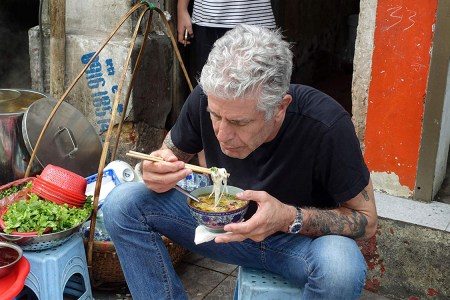 Anthony Bourdain tucking into a bowl of noodles on the set of Parts Unknown, 2013 (Credit: IMDB). 