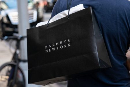 A man carries a Barneys New York shopping bag. (Drew Angerer/Getty)