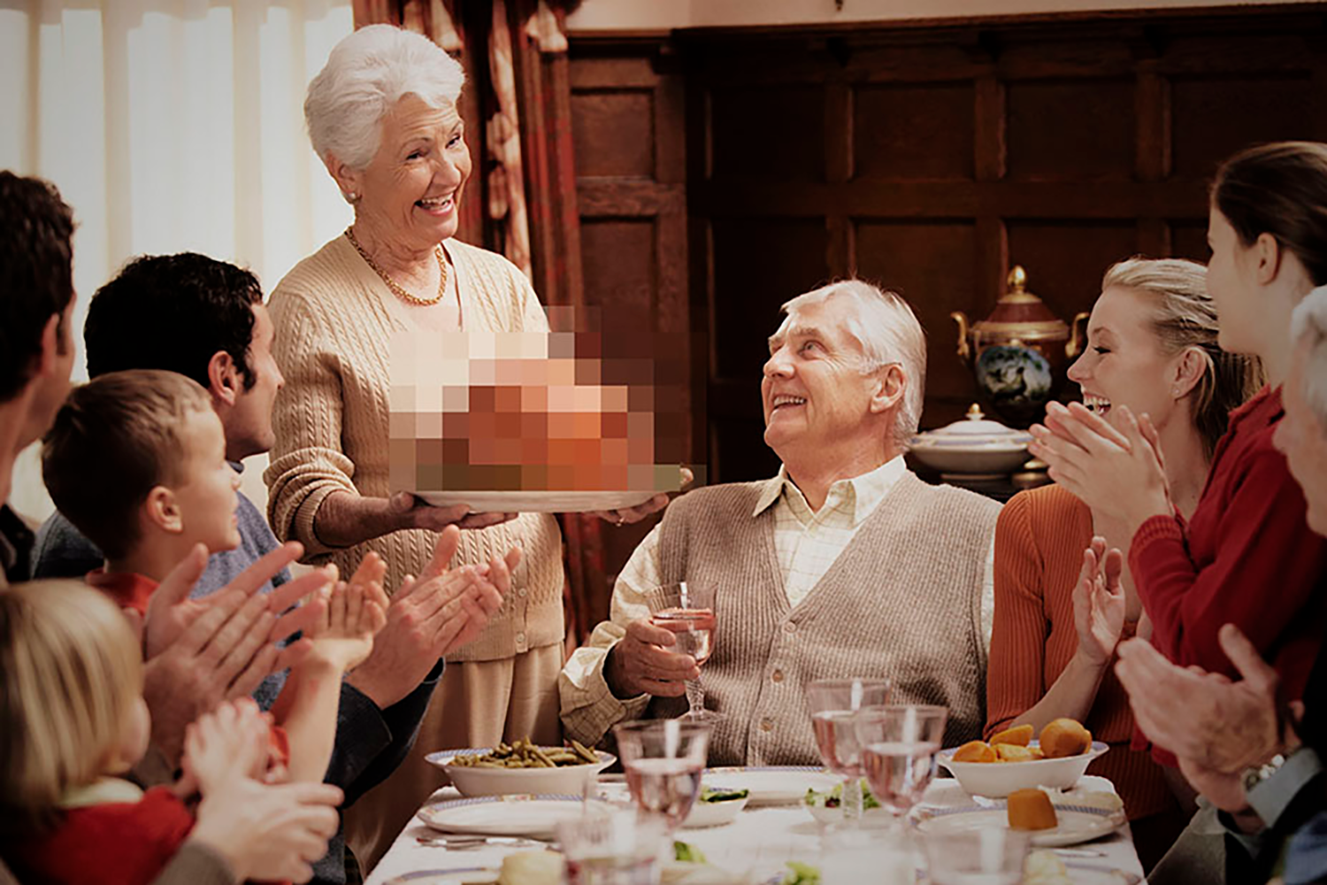 Family sitting down for Thanksgiving dinner, turkey is blurred out