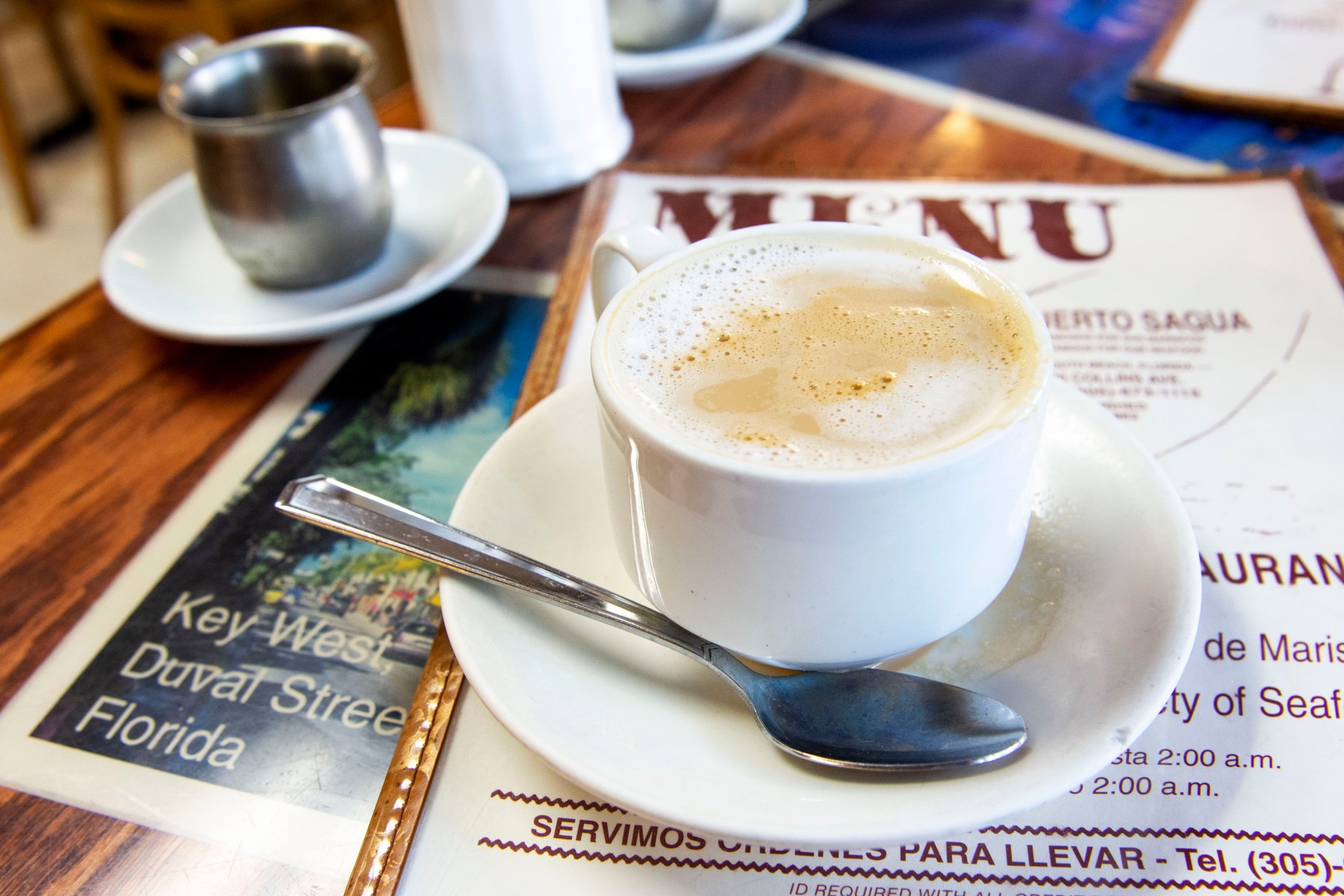 We have a long night ahead of us, so we start with a definitive beverage: café con leche. As is custom,<br>we pour the hot coffee from a tiny silver pitcher into the white ceramic mug of warm milk, clinking gently<br>with a silver spoon when we stir. The milk is frothy, the coffee strong.