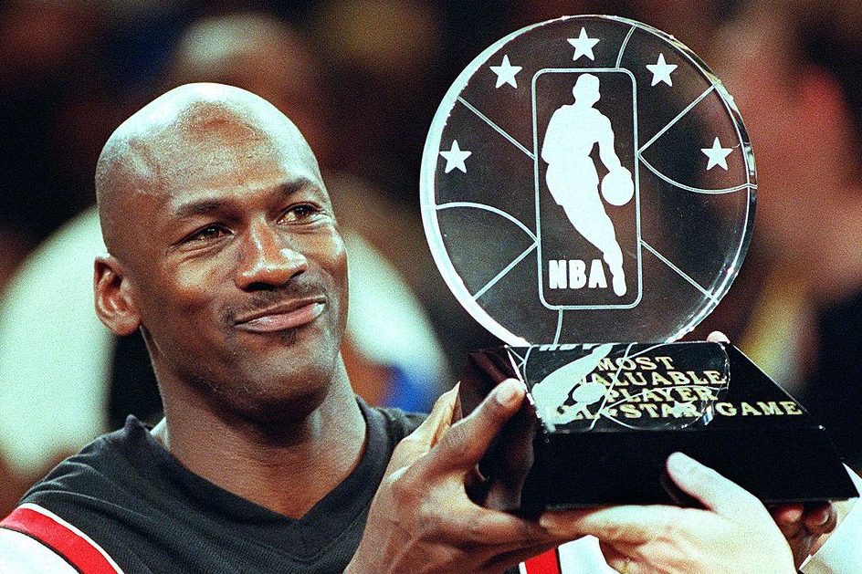 Michael Jordan holds up the Most Valuable Player trophy at the All-Star game. (TIM CLARY/AFP via Getty)