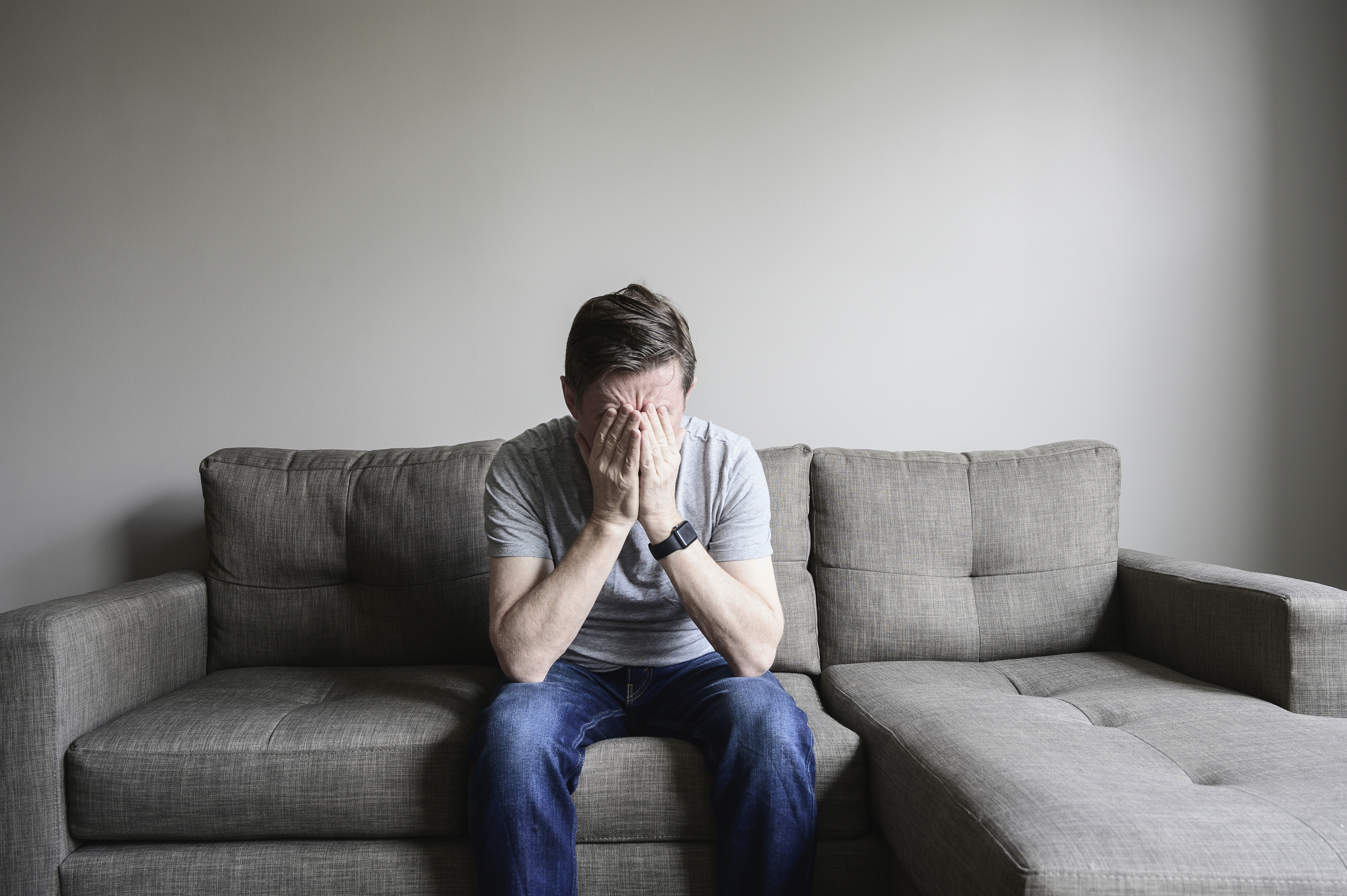 unhappy person sitting on couch in despair