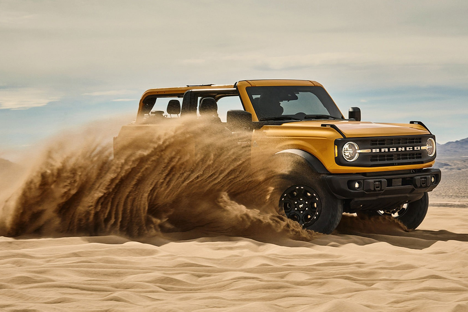 yellow 2021 Ford Bronco SUV driving in the sand