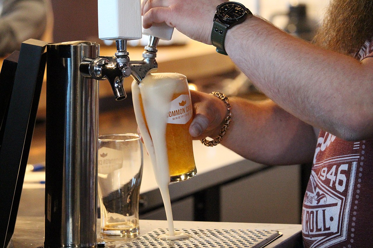 beer glass overflowing under the tap