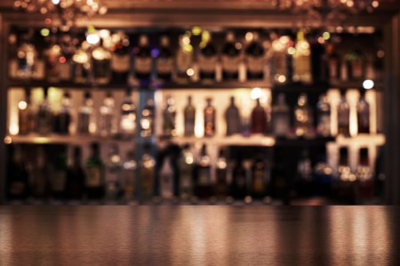 empty wooden bar with booze in the background