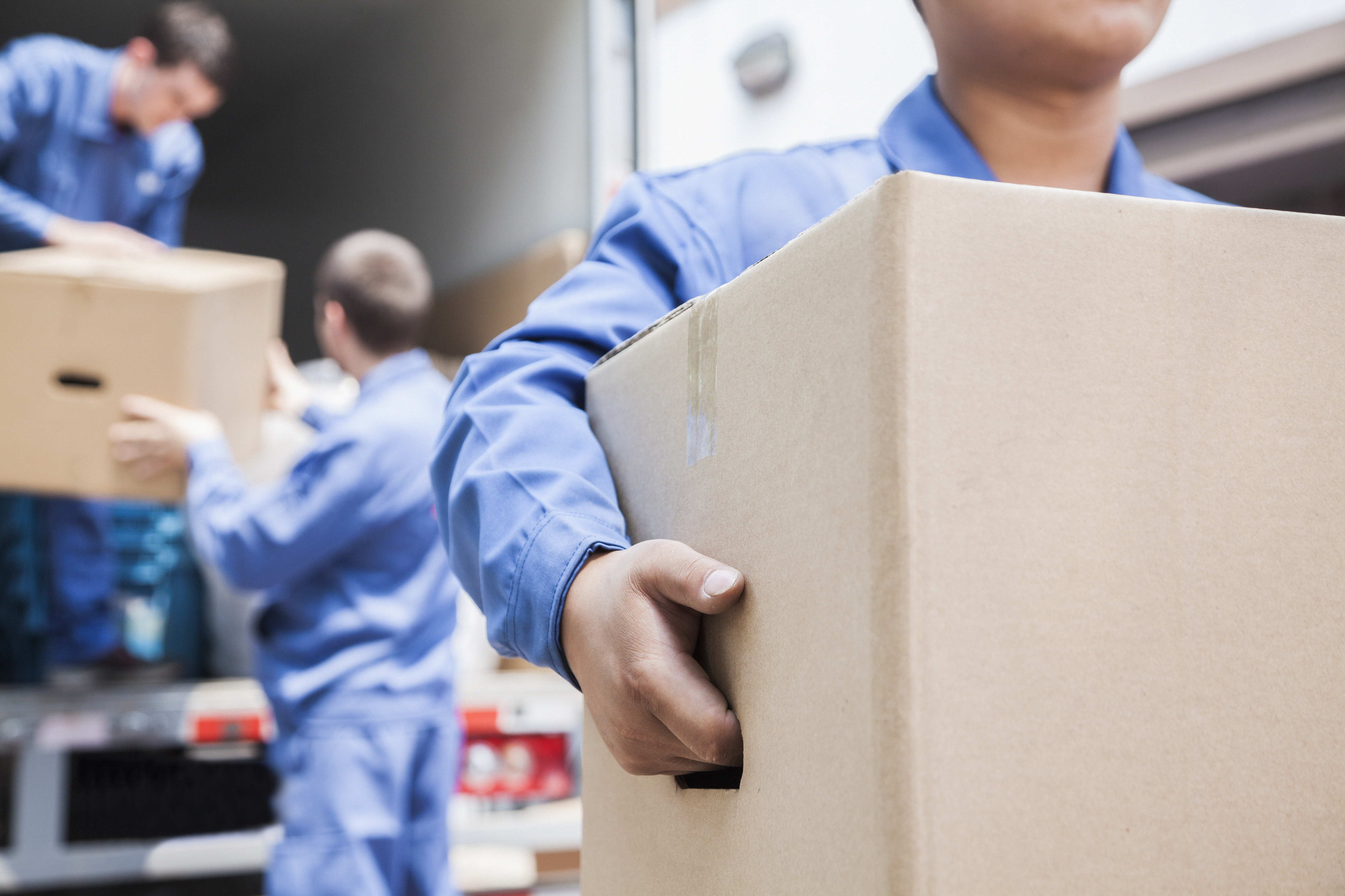 three movers unloading carboard boxes