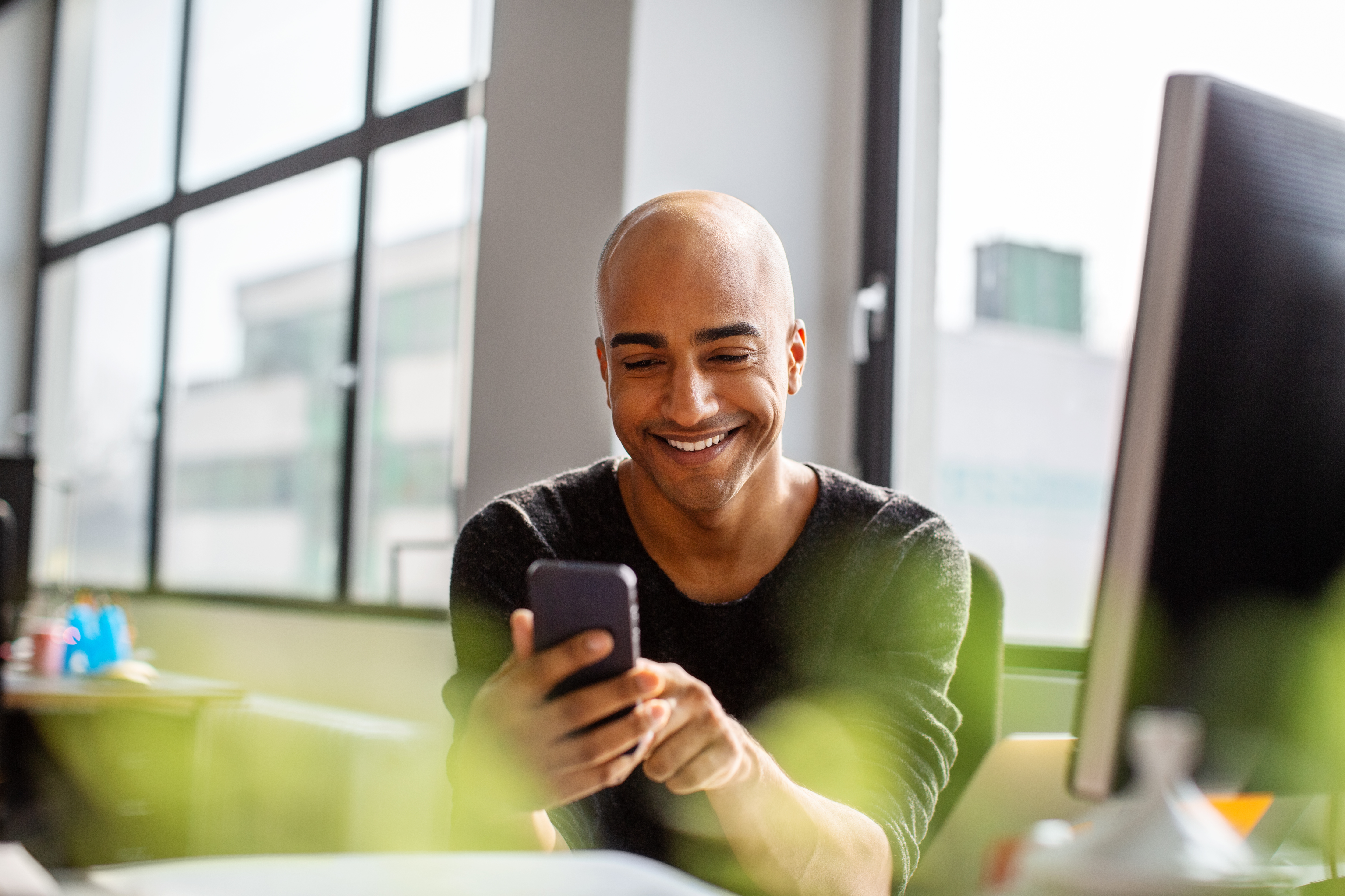 bald man holding phone