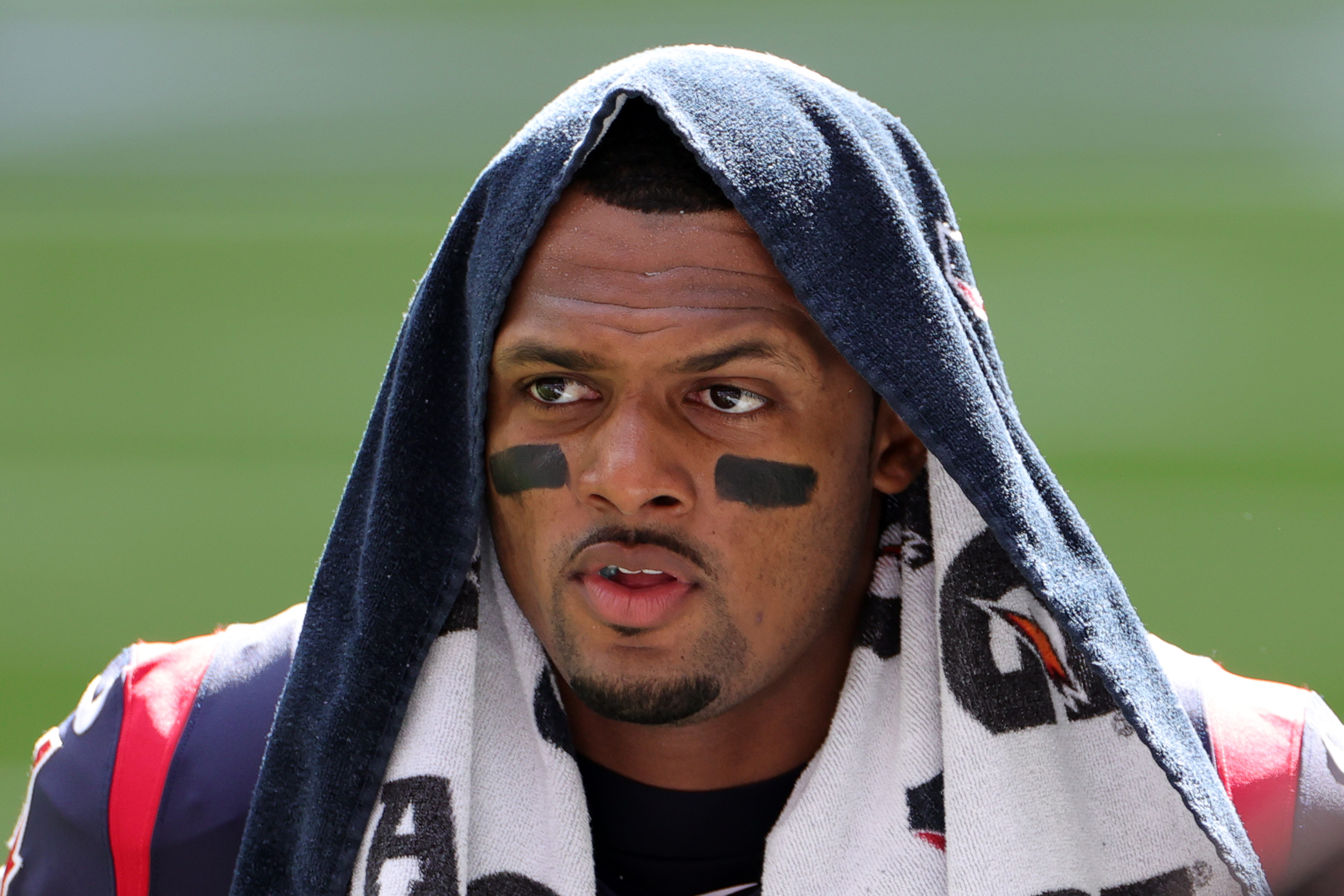 Quarterback Deshaun Watson walks the field during warmups with a towel on his head