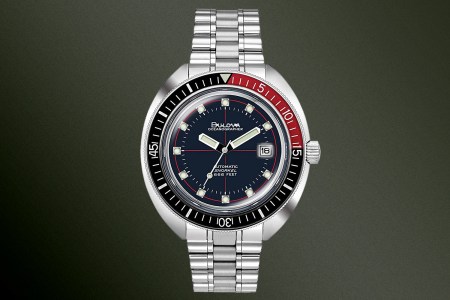 A Bulova Oceanographer Devil Diver watch in red and black on a green background