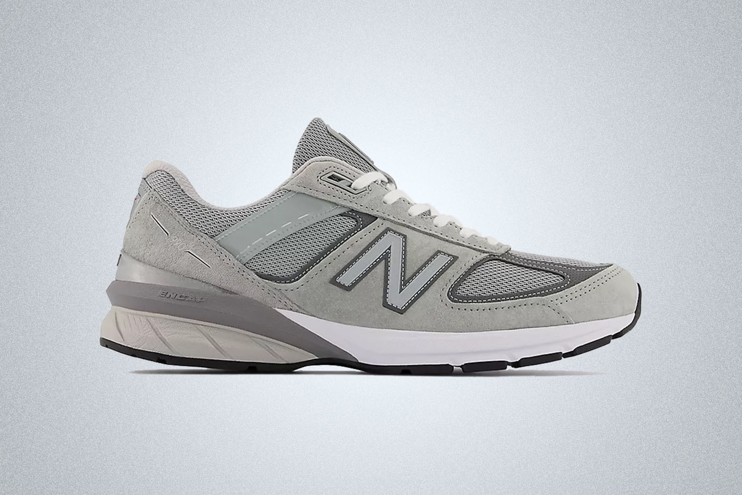 a grey New Balance Model 990v5 sneaker on a grey background