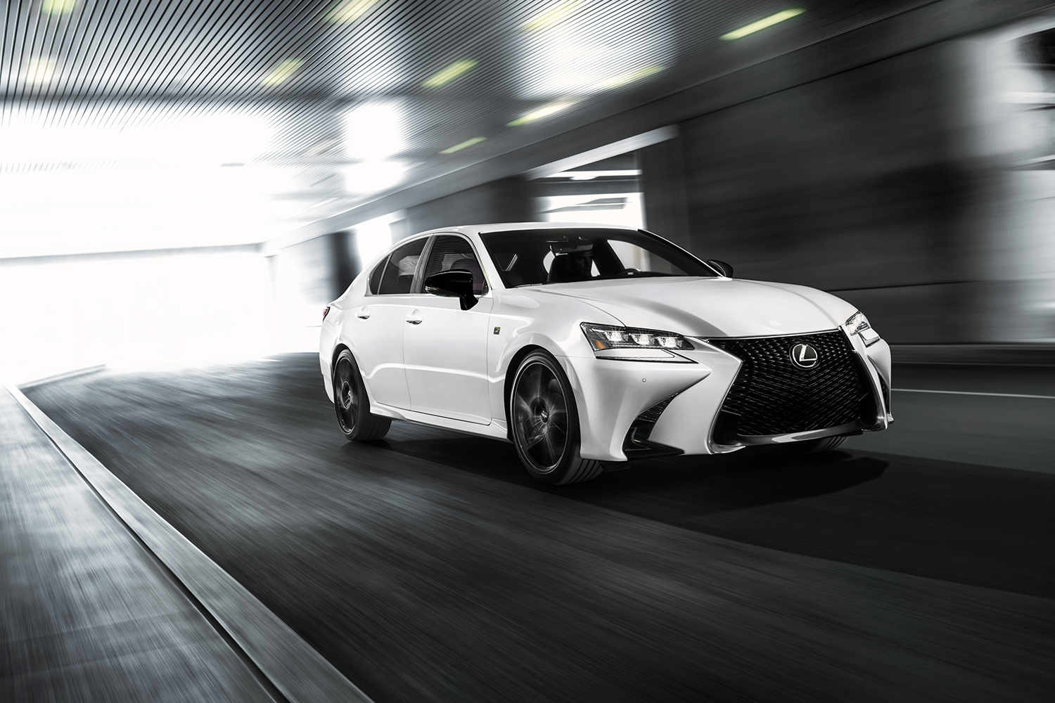 A white Lexus GS driving underground with daylight behind it