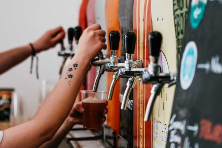 two bartenders grabbing beer from taps