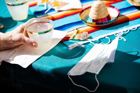 A mask is left on a table next to a margarita at Moldaw Residences in Palo Alto, Calif., on Monday, Feb. 22, 2021.