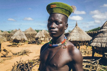 a karamajong man with scars on his face forming a pattern as a beauty and identity sign