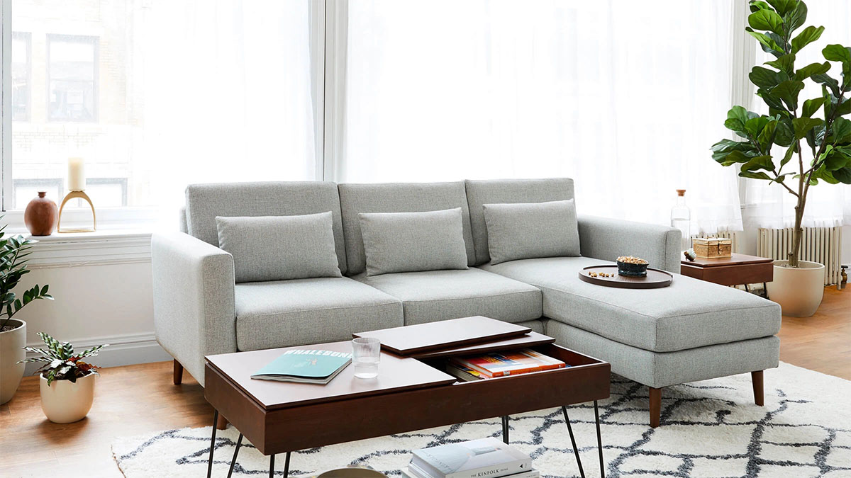 a grey Burrow modular sectional couch staged in a room with a wooden coffee table