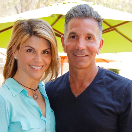 Lori Loughlin and Mossimo Giannulli pose outdoors under green sun umbrella