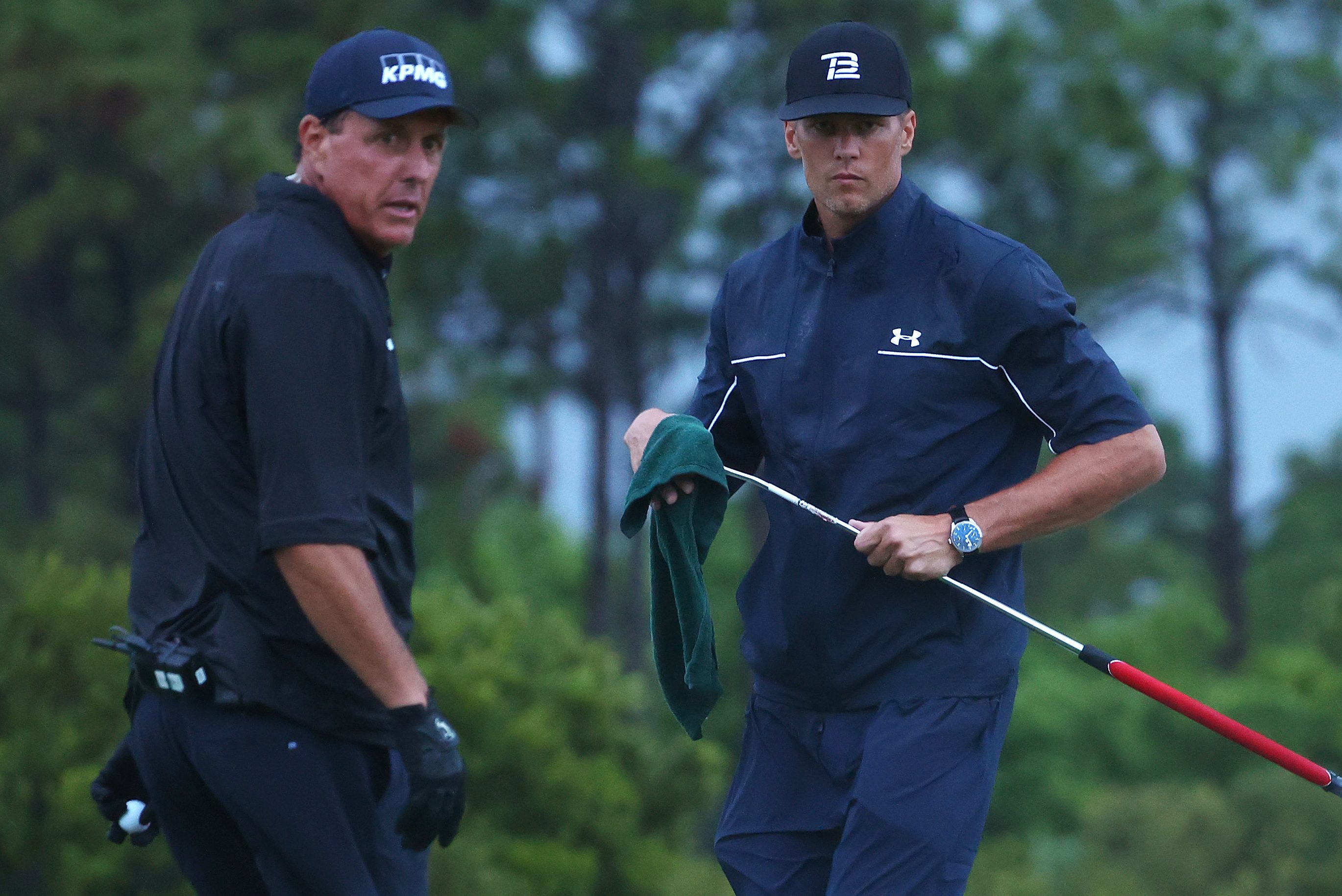 Phil Mickelson reads a putt for Tom Brady