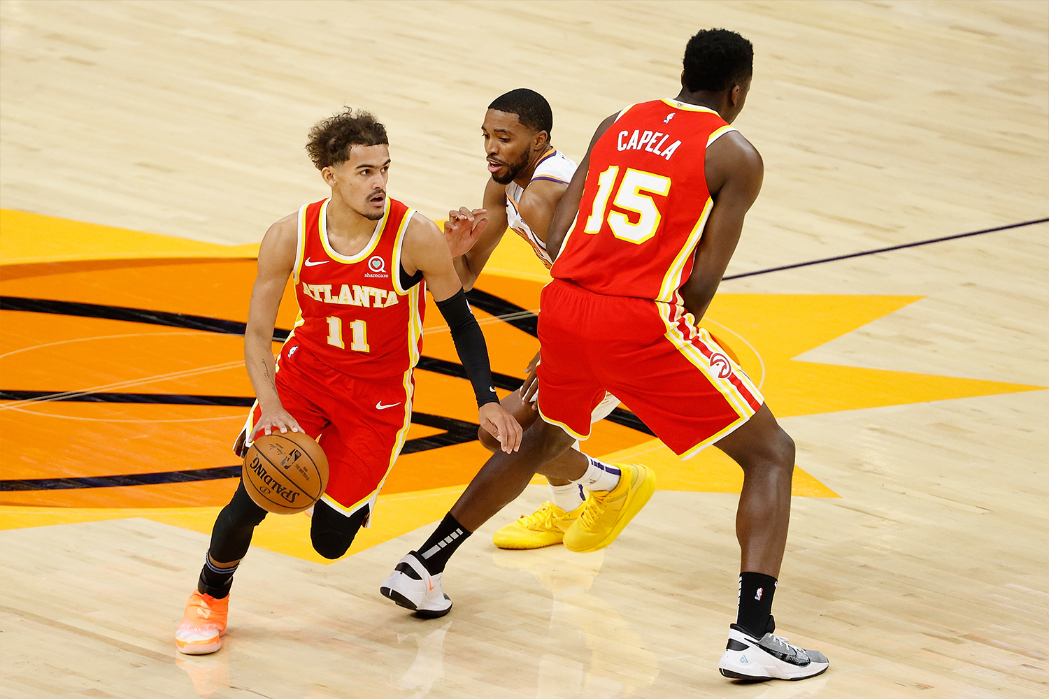 Trae Young #11 of the Atlanta Hawks moves the ball past Mikal Bridges #25 of the Phoenix Suns