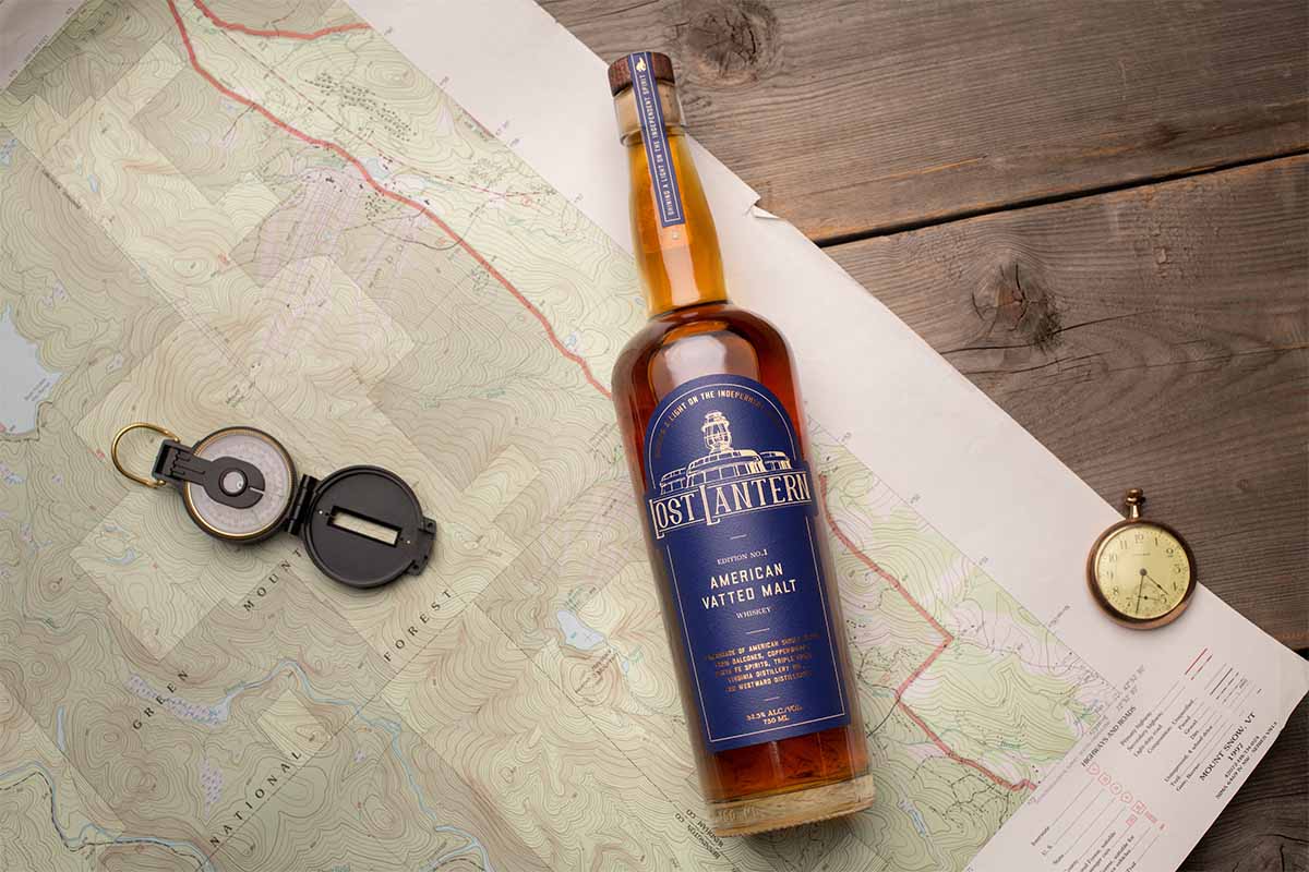 A bottle of Lost Lantern's American Vatted Malt release on a desk with a map