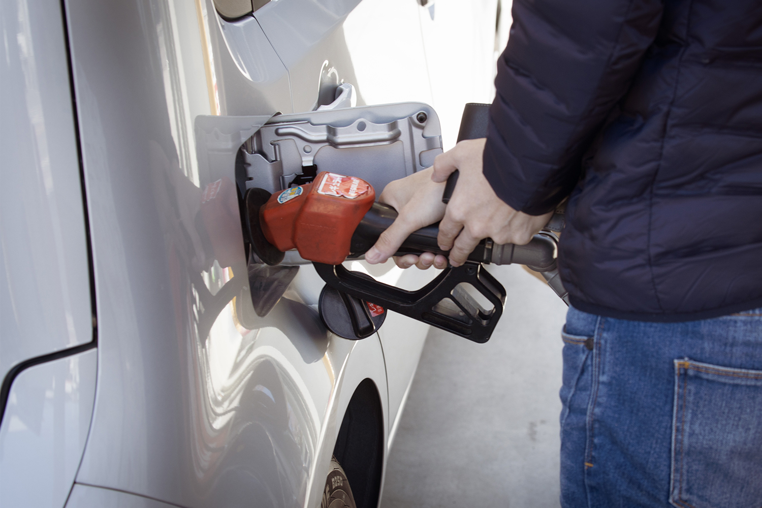 A person pumping gas into a vehicle at a gas station