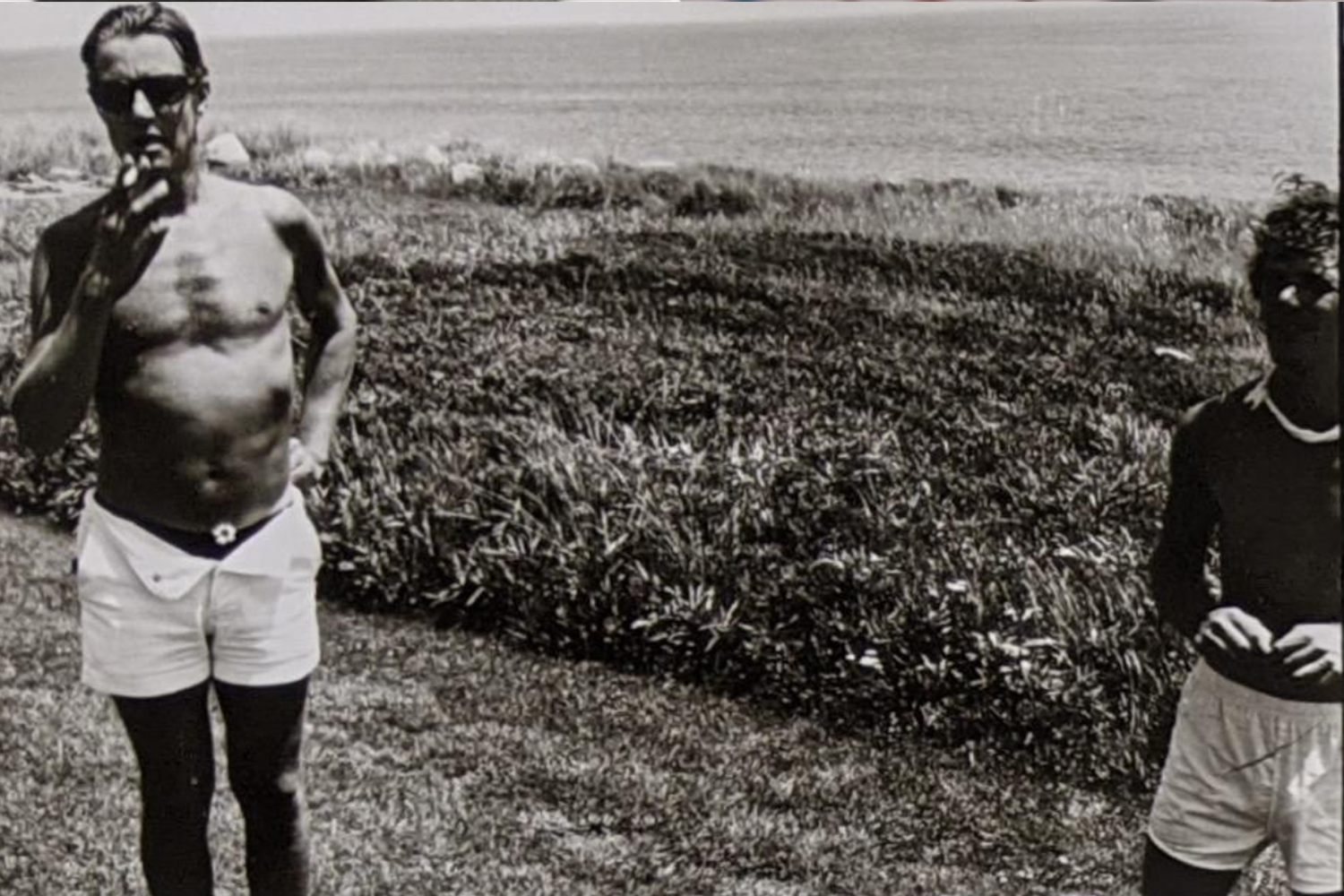 Halston displays his own flower arrangement as Peter Wise looks on, Montauk