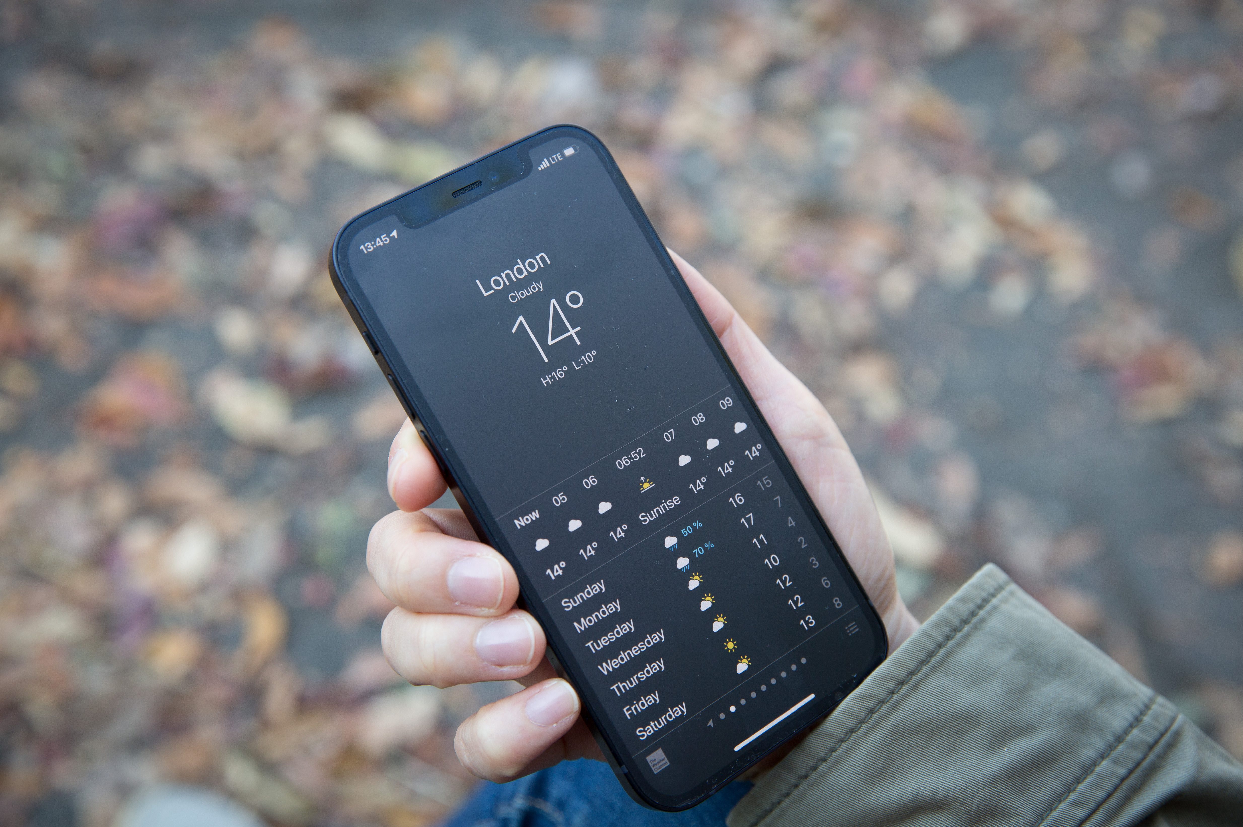 In this photo illustration a woman holds the new iPhone 12. The weather app for Apple reportedly won't show if it's 69 degrees.