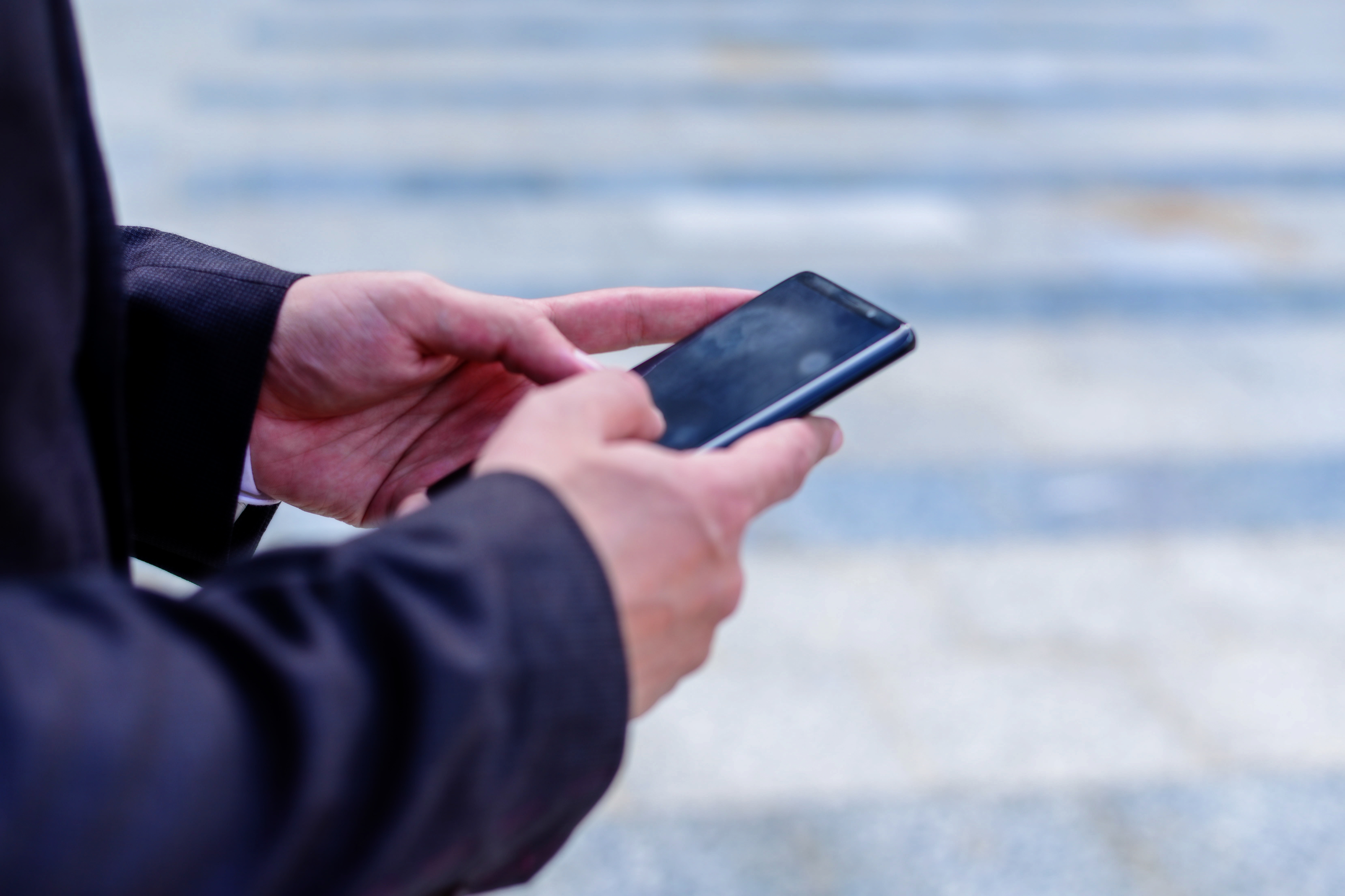 man's hands holding cell phone