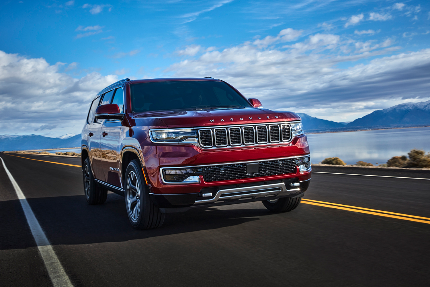 A red 2022 Jeep Grand Wagoneer driving along. The new luxury SUV has horrible gas mileage, proving we need stricter fuel economy standards.