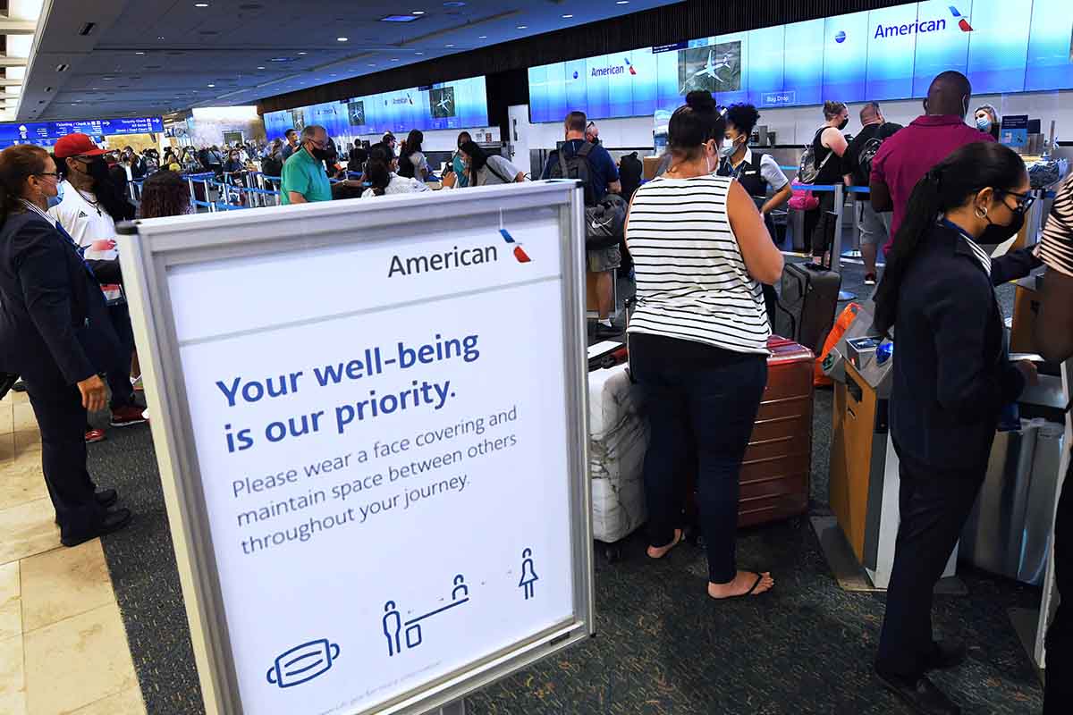 Travelers wearing face masks as a preventive measure against the spread of covid-19 wait in line at the American Airlines ticket counter at Orlando International Airport. People defying the mask mandate is one of the major issues for airlines -- the FAA has handed out over $1 million in fine to unruly fliers.