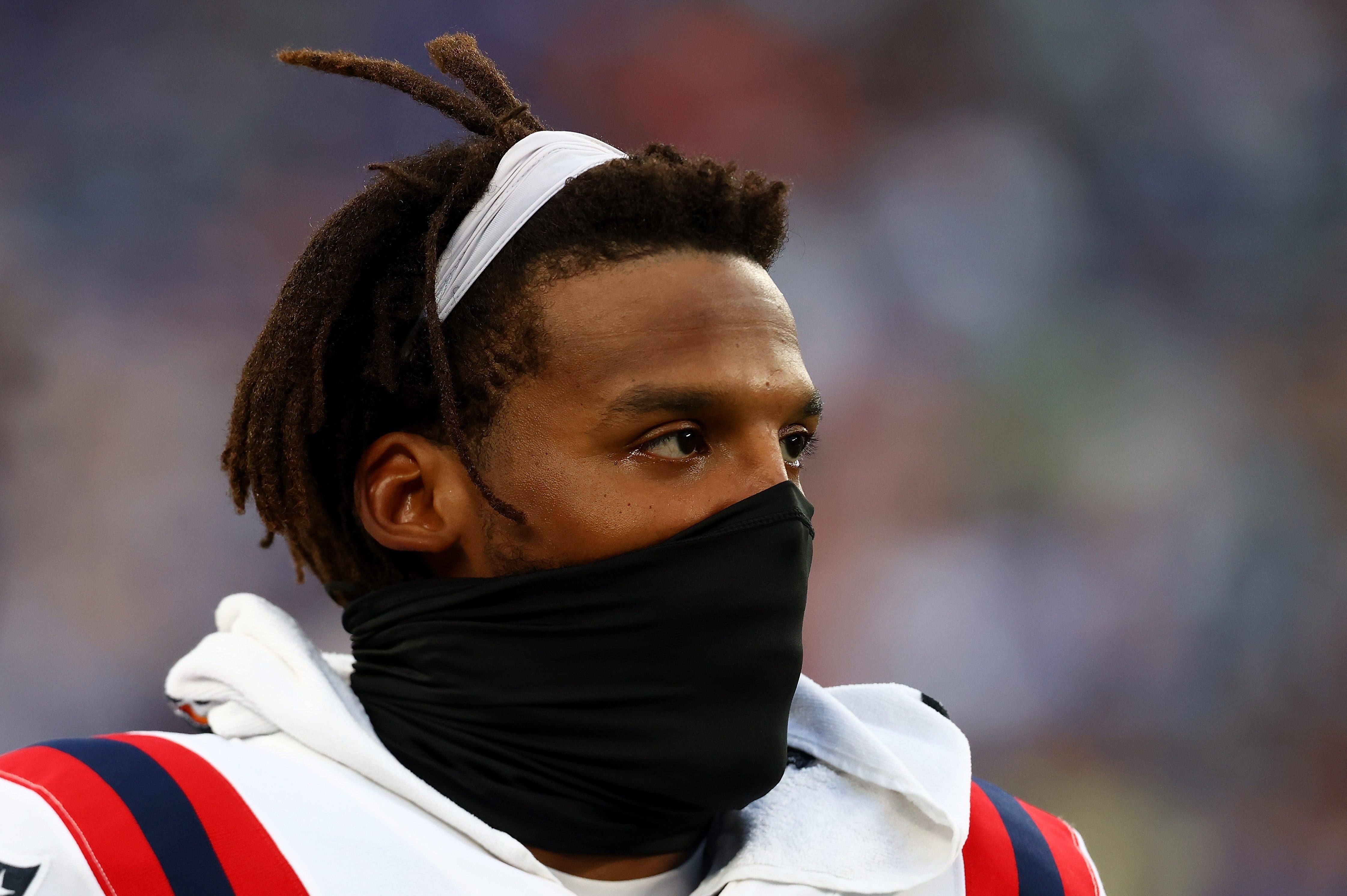 Cam Newton looks on from the bench during his final game with the New England Patriots. The QB was surprisingly cut before the season's start.