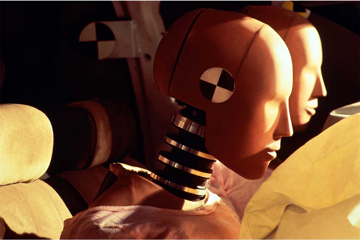 Crash-test dummies inside car with inflated airbags, close-up. Women are more likely to be hurt than men in car crashes due to poor design from government agencies who use crash test dummies.