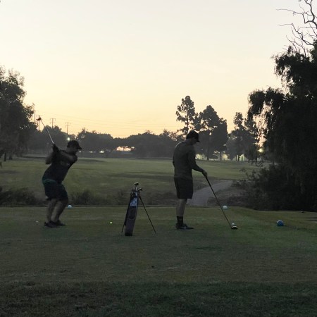 speedgolfers teeing off in the dark