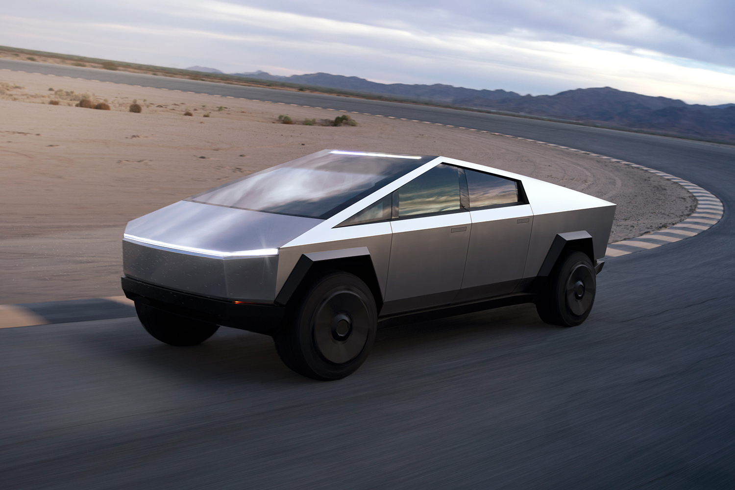 The electric Cybertruck pickup from Tesla driving down a road in the desert. We suggest a moratorium on Cybertruck news until Elon Musk's company actually builds it.