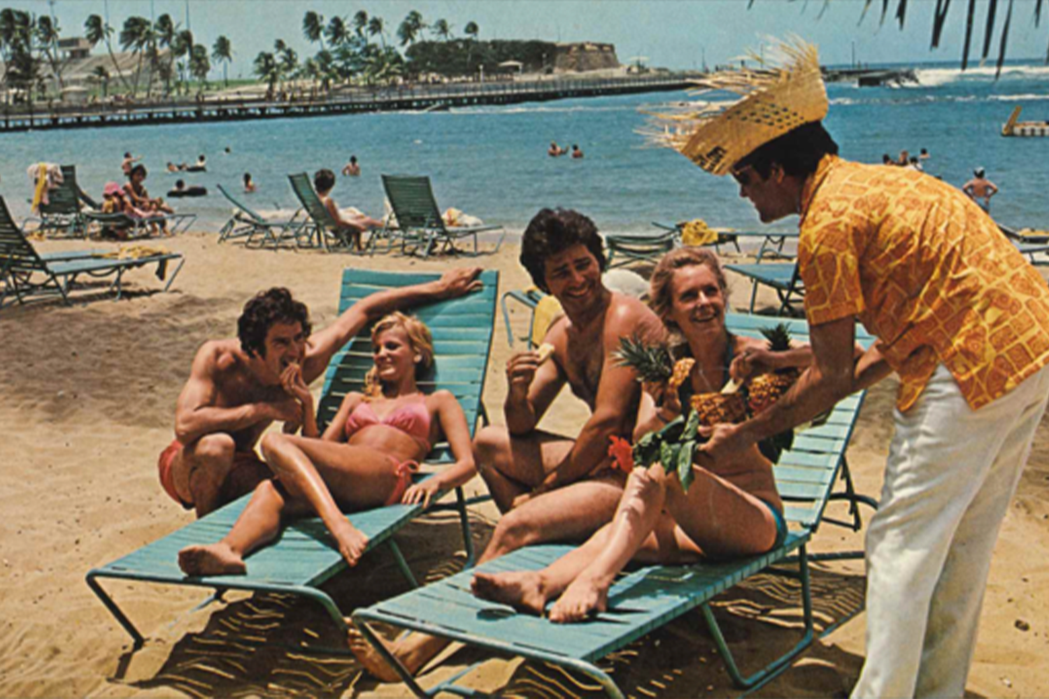 A butler serves piña coladas in halved pineapples at the Caribe Hilton in San Juan