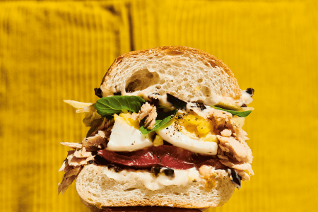 Molly Baz's Nicoise sando on a bright yellow background