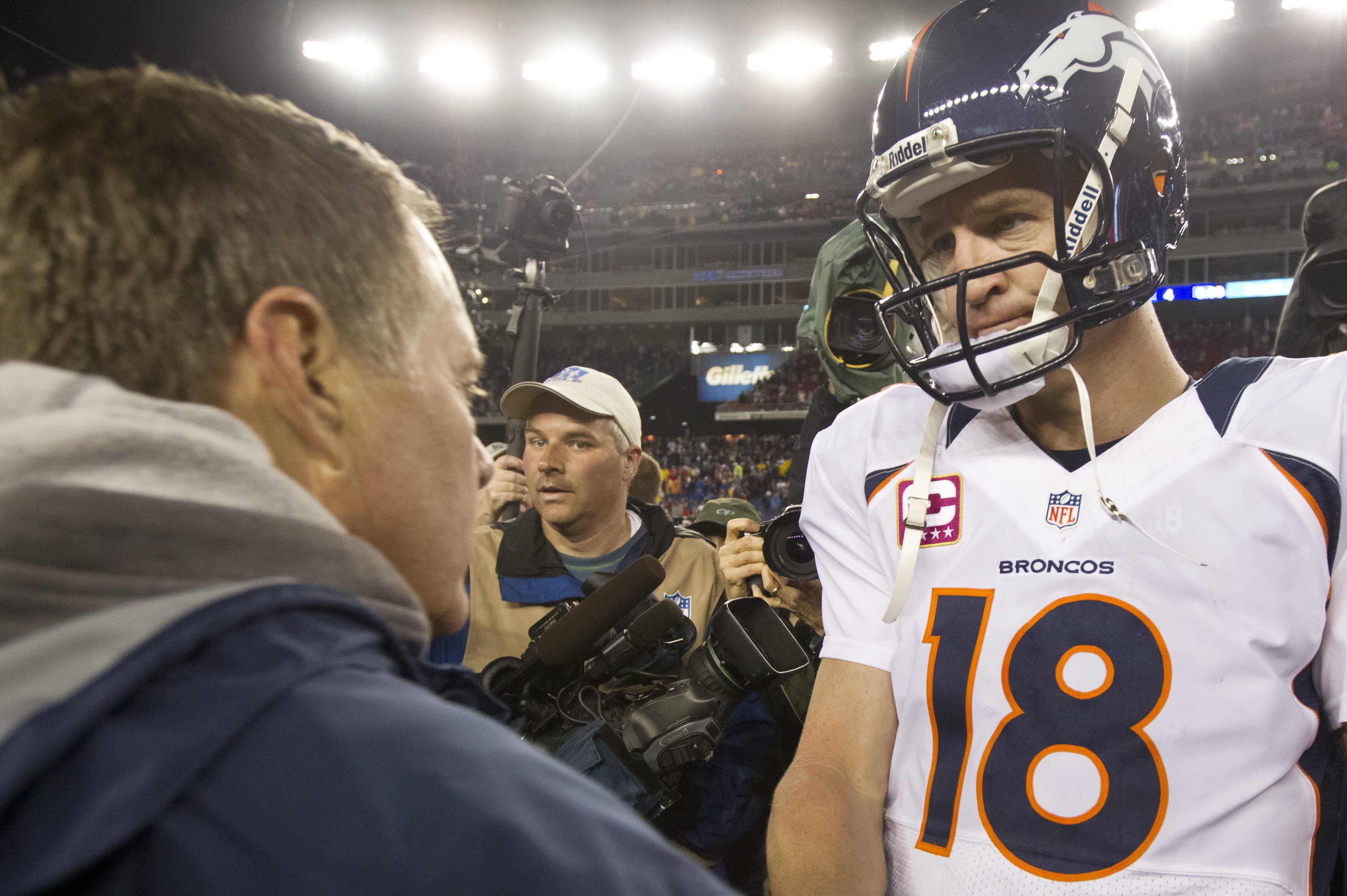 Patriots head coach Bill Belichick shakes hands with former Broncos QB Peyton Manning. The QB claims he was worried New England had bugged his locker room.