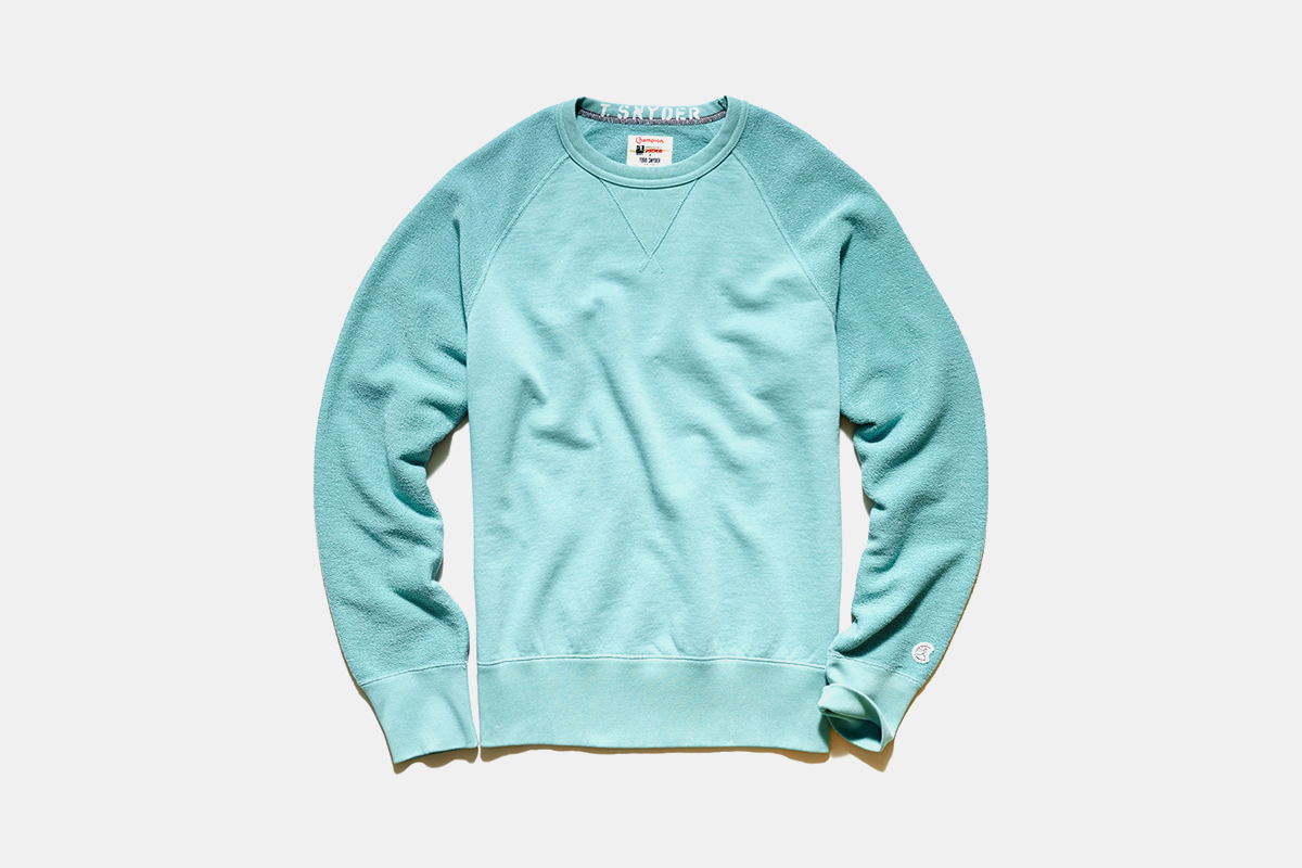 A light blue Todd Snyder sweatshirt against a grey background.