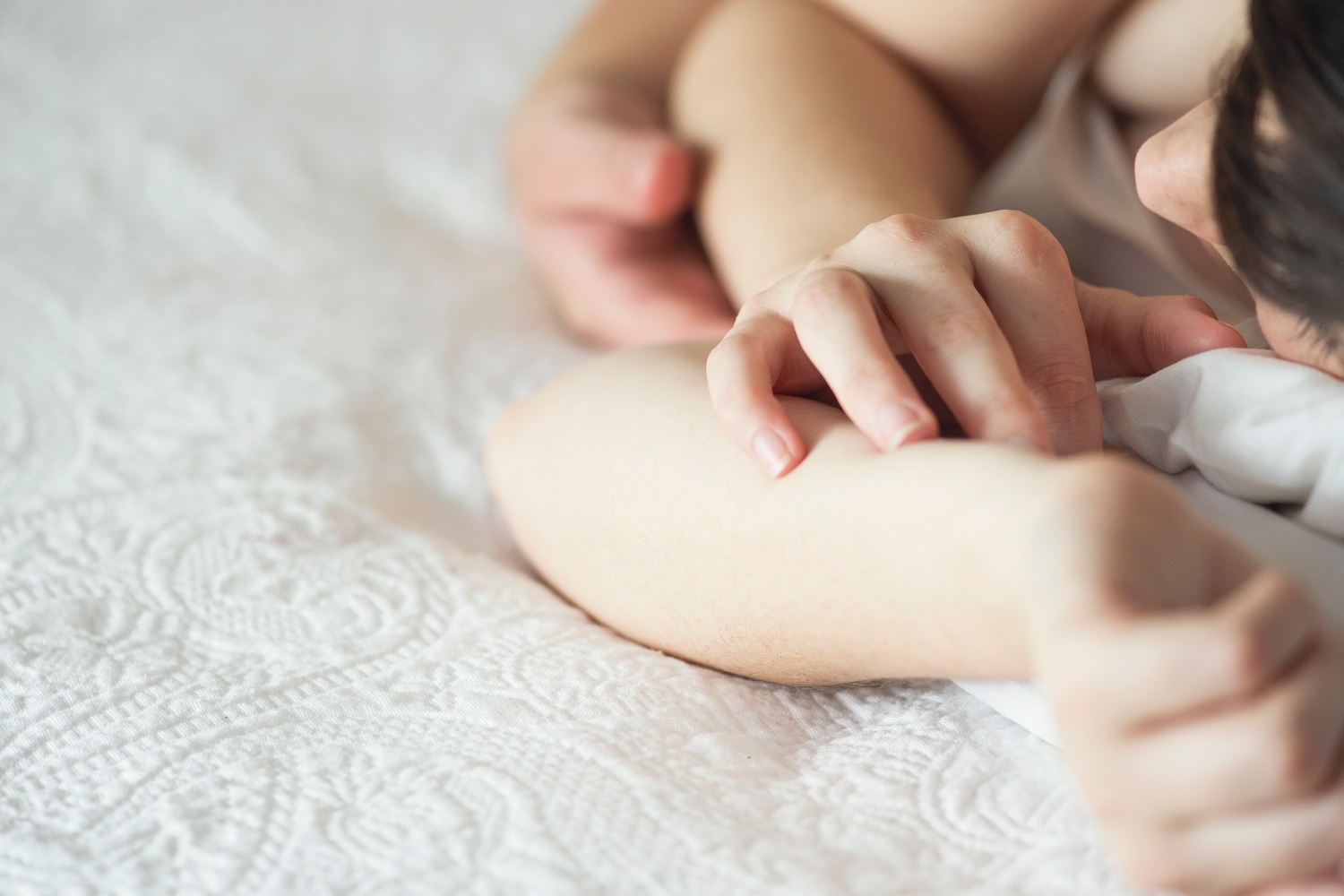 Couple lying in bed together holding hands