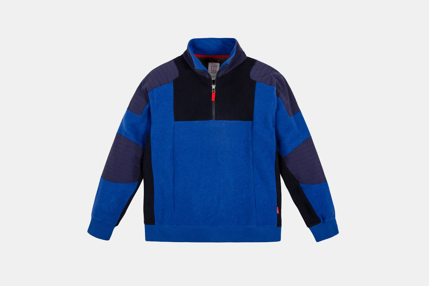 The Global 1/4 Zip Sweater from Topo Designs in blue and black on a grey background