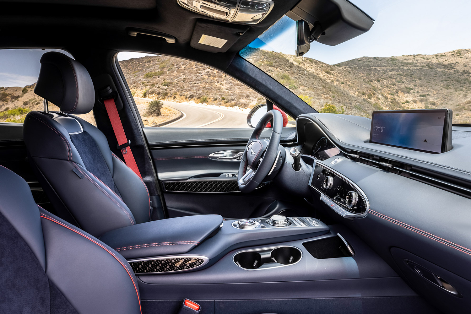 The interior of the new Genesis GV70 SUV showing the front two seats, steering wheel and infotainment