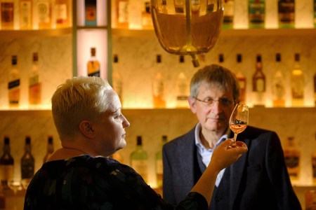 Emma Walker succeeds Jim Beveridge OBE becoming the first female Master Blender in the 200-year Johnnie Walker story. Here they are at a bar with Walker swirling Scotch in a glass.