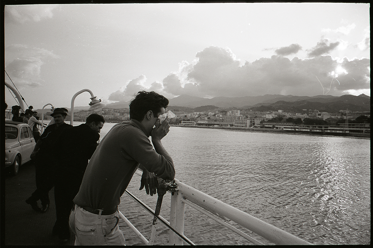 An immigrant man crying on a boat.