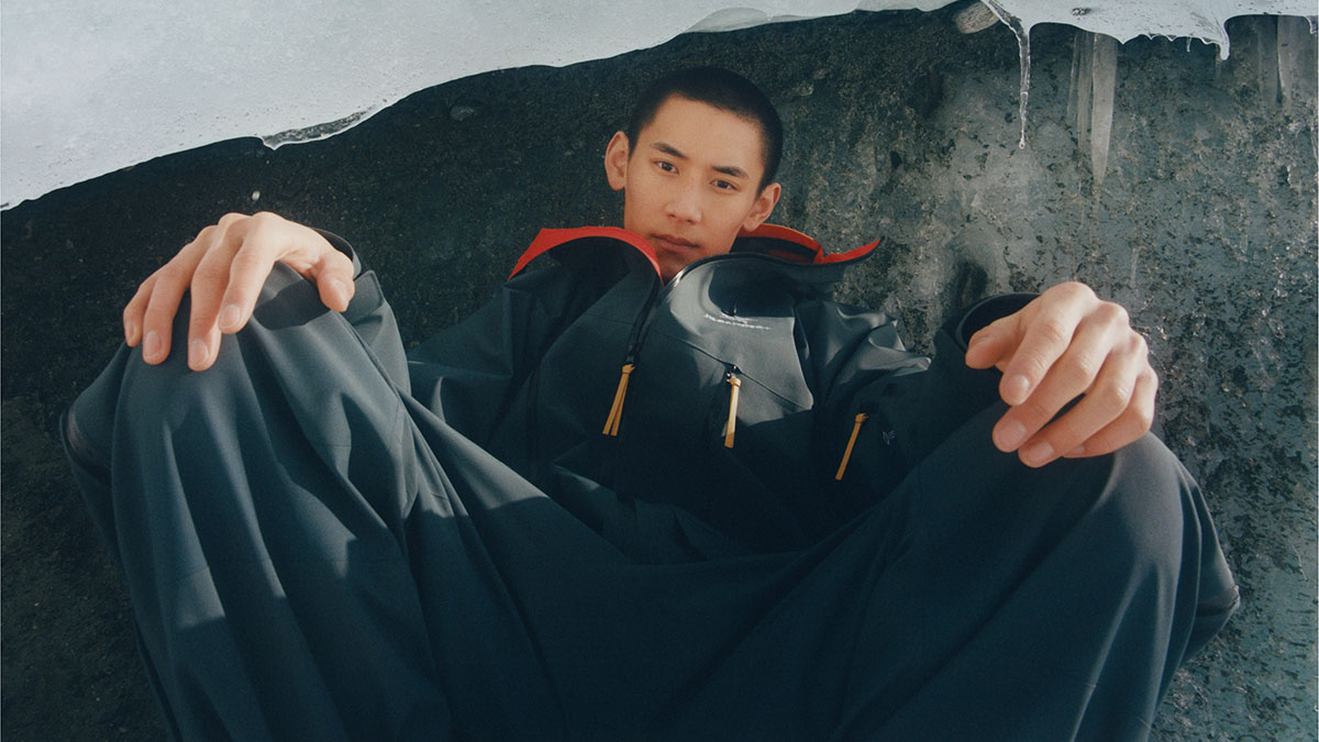 a man sitting in a frozen lace with a collaboration jacket on