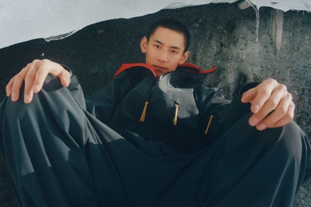 a man sitting in a frozen lace with a collaboration jacket on