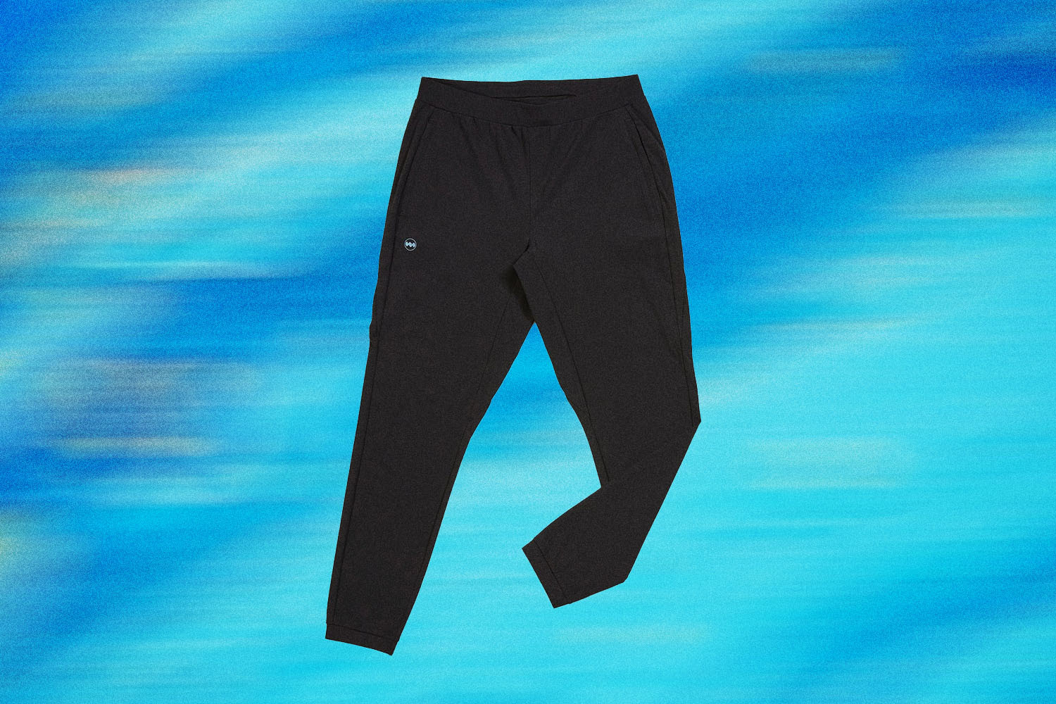 Janji Mercury Track Pants on a blue background.