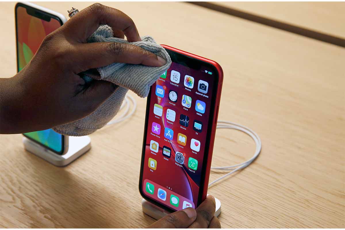 An employee cleans an iPhone Apple XR during the press visit of the new Apple Store Champs-Elysees on November 15, 2018 in Paris, France. Polishing costs at Apple cost $19, which is a common price point for their smaller accessories.