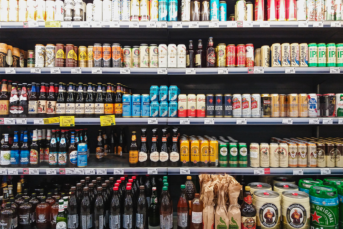 Beers on shelves in a grocery store.