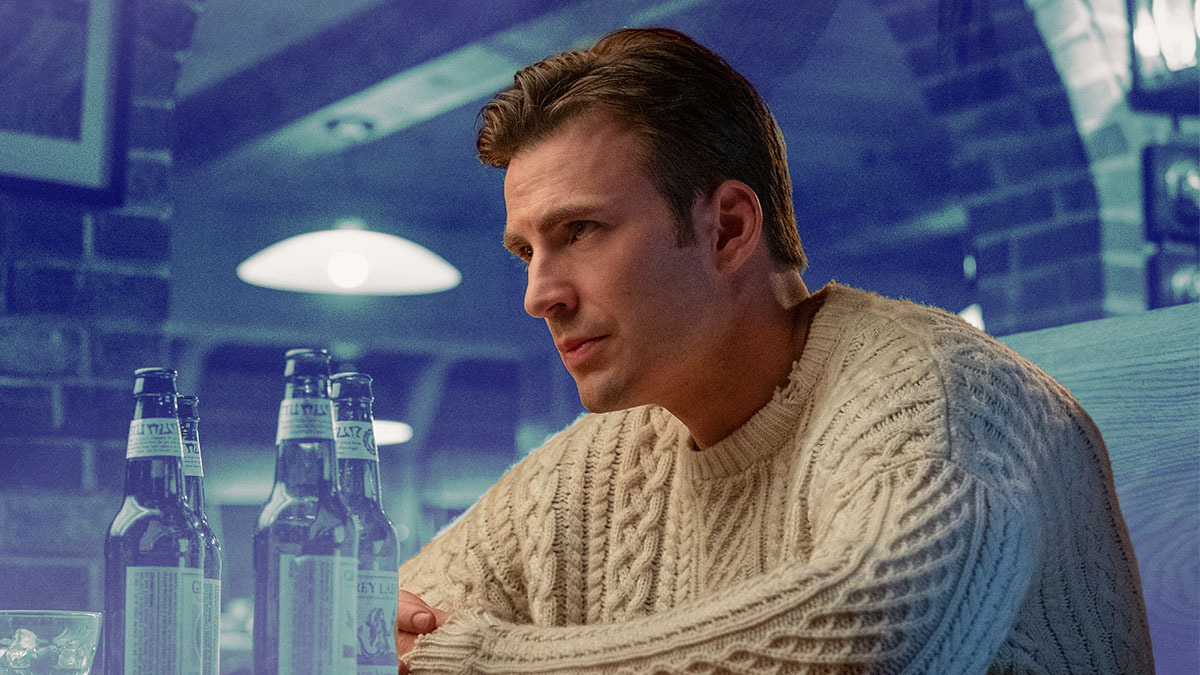 Chris Evans in the movie Knives Out wearing a white fisherman sweater on a blue toned background