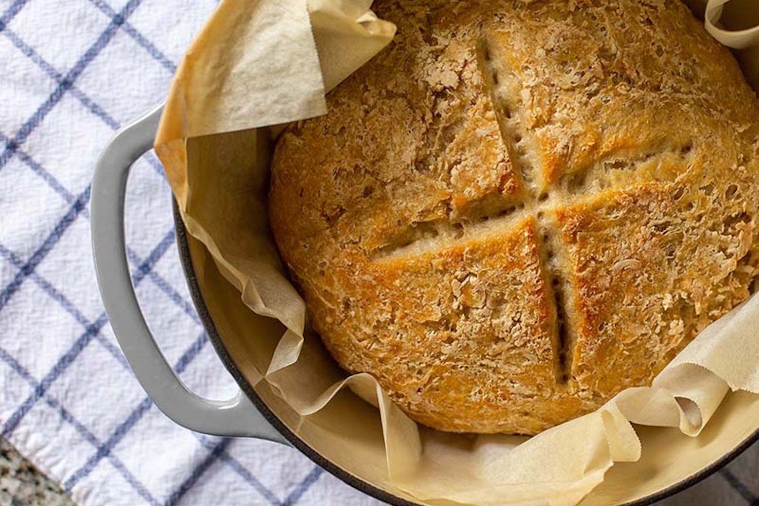 a loaf of bread inside of a silver Lodge Cast Iron dutch oven